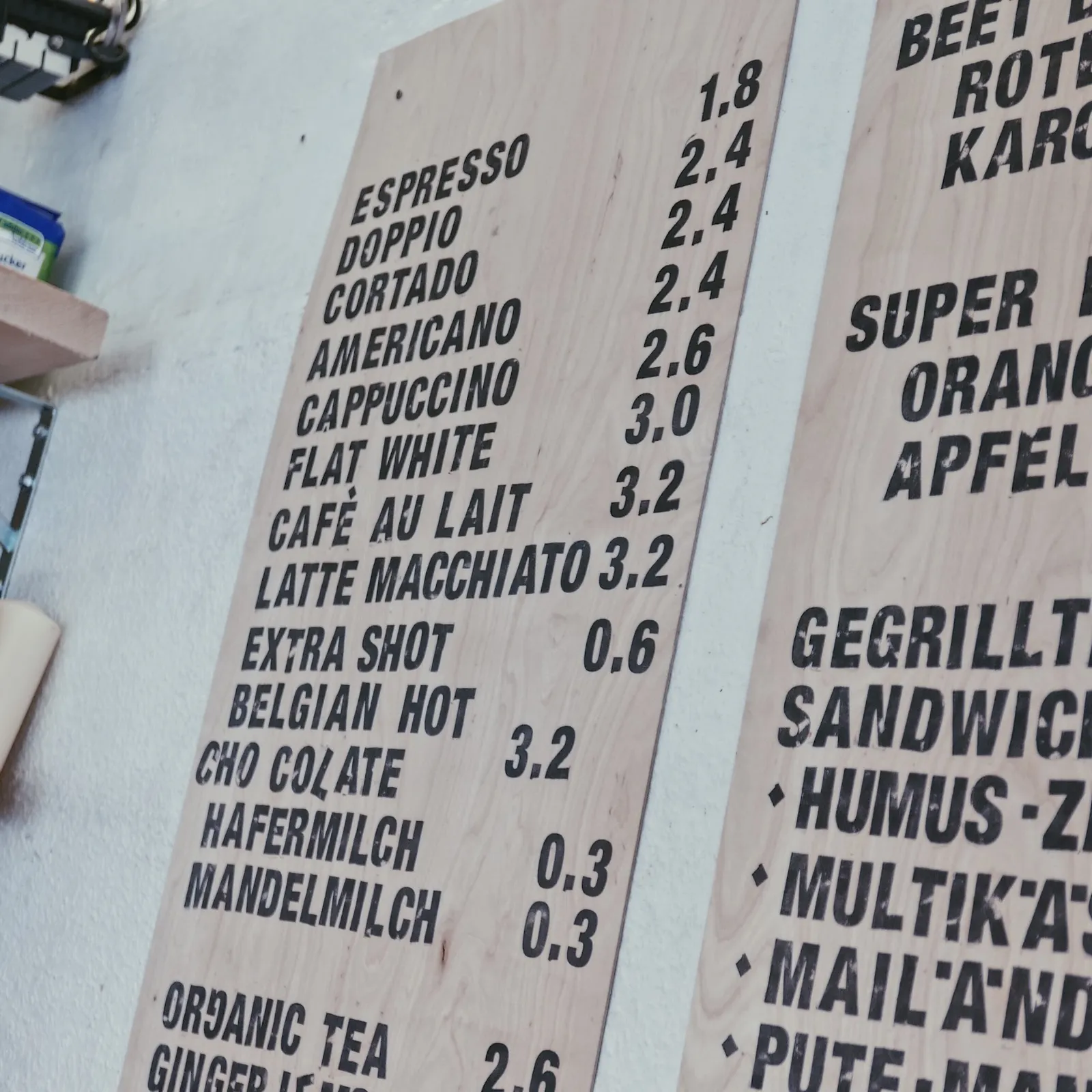 Belegtes Sandwich und Cappuccino auf rotem Tisch
