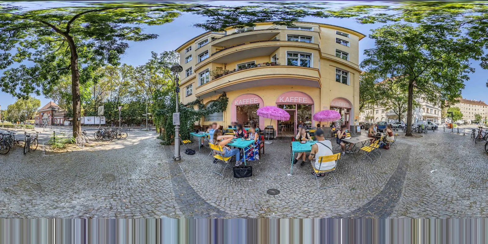 Außenansicht des Cafés mit rosa Sonnenschirmen