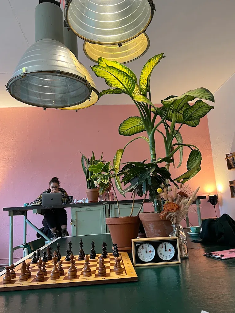 Innenraum mit Pflanzen, Schachbrett und warmem Licht